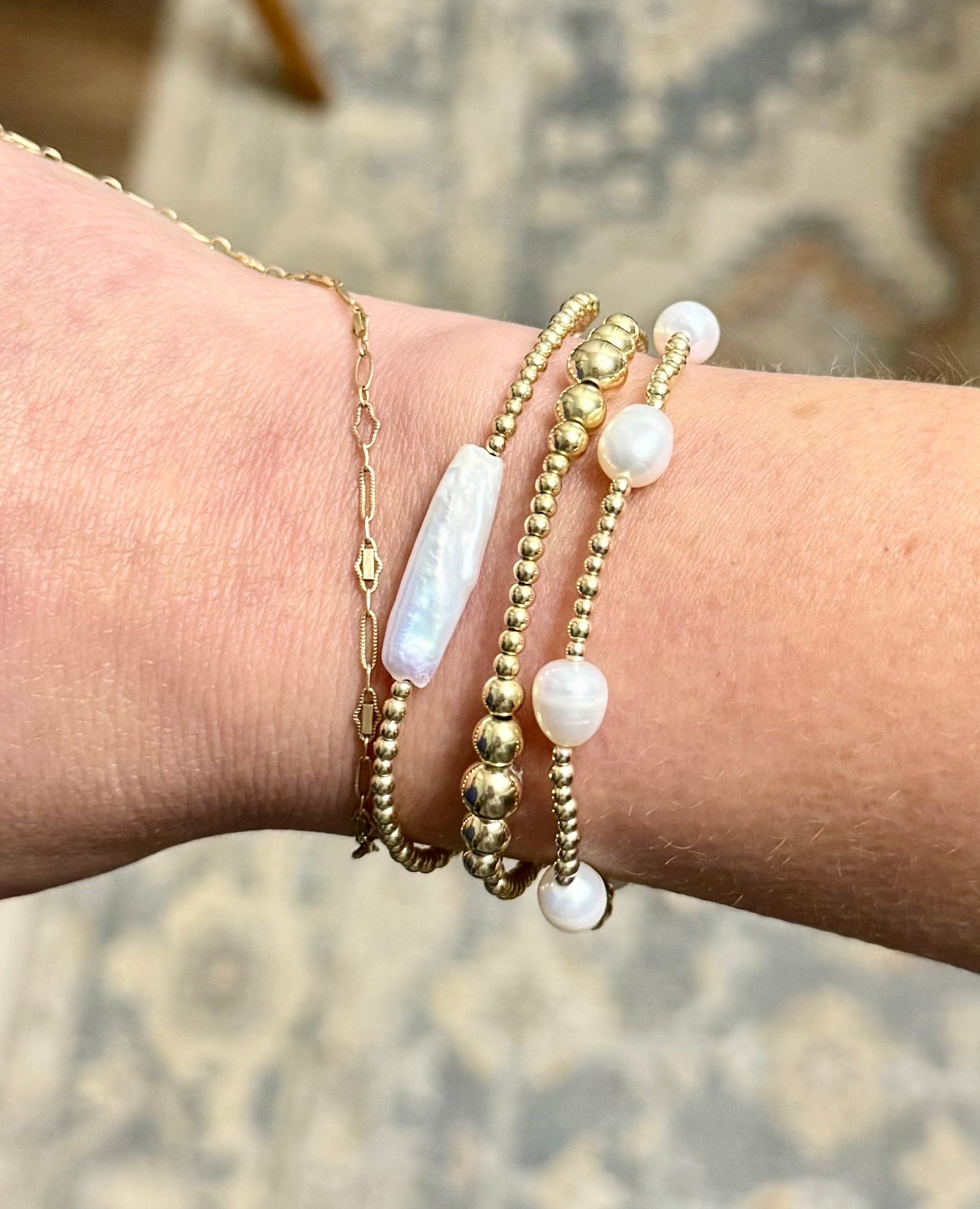 Freshwater pearl and 14K gold-filled beaded bracelets stacked on wrist