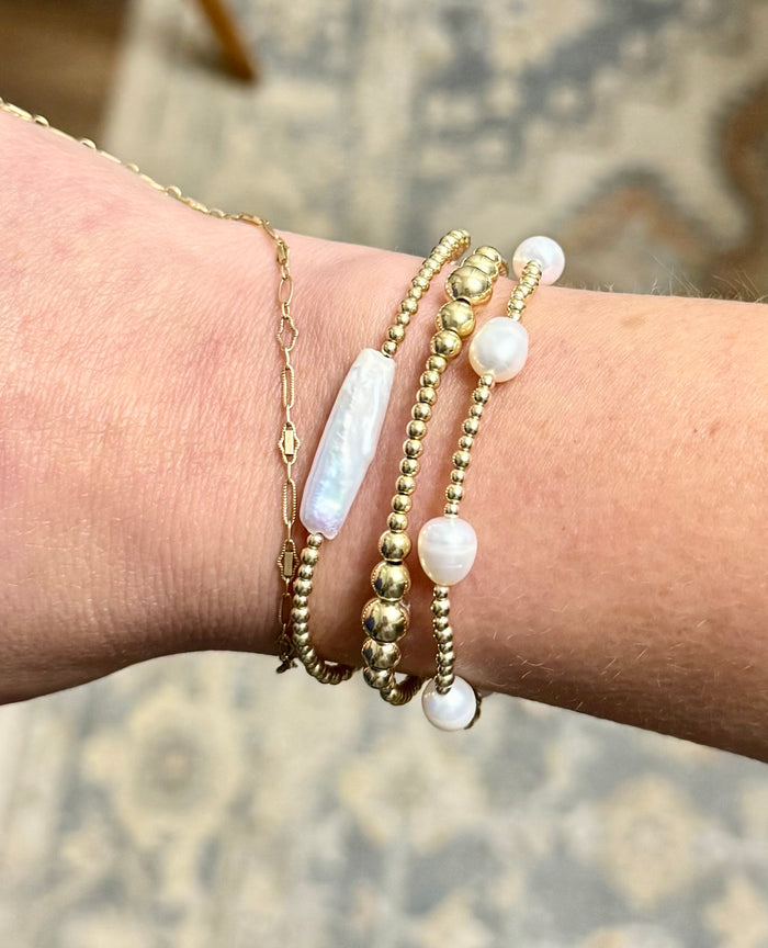 Freshwater pearl and 14K gold-filled beaded bracelets stacked on wrist