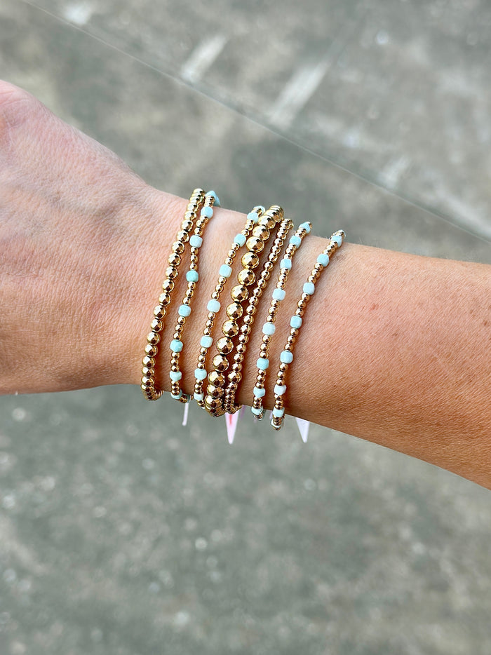 Gold filled beaded bracelet stack featuring colorful gemstone cross bracelets and classic gold filled styles