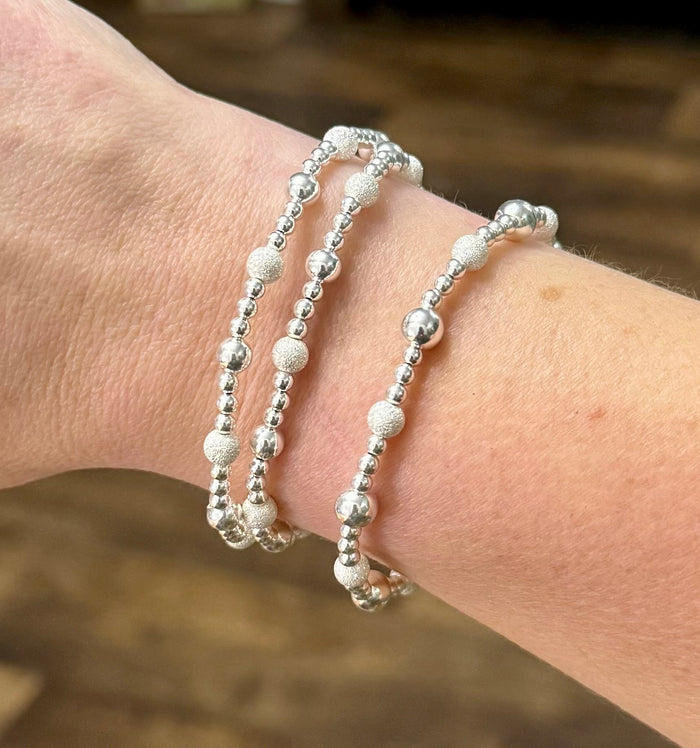 Sterling silver beaded bracelet stack featuring smooth and stardust beads in multiple sizes