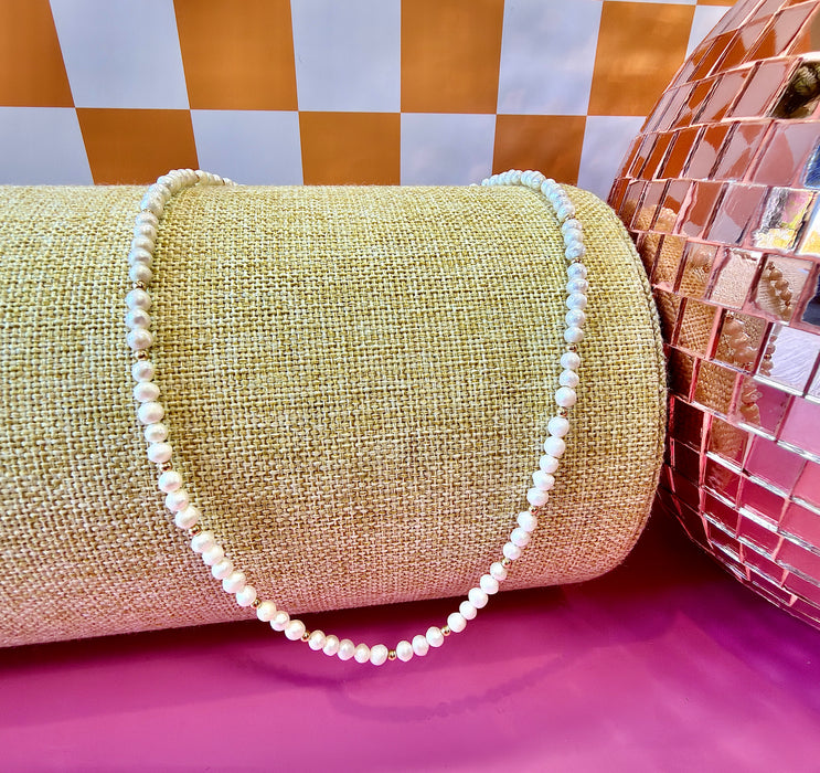 Goldie freshwater pearl necklace with dainty gold-filled accents on jewelry display
