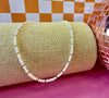 Goldie freshwater pearl necklace with gold-filled accent beads displayed on a linen jewelry stand