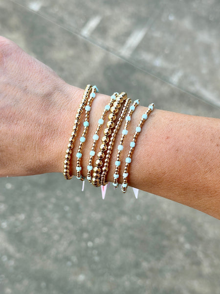 Amazonite cube and 14K gold filled beaded bracelets layered in a gold bracelet stack