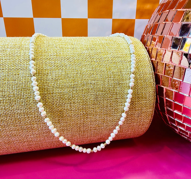 Freshwater pearl and gold-filled bead Goldie Necklace displayed with pink disco ball