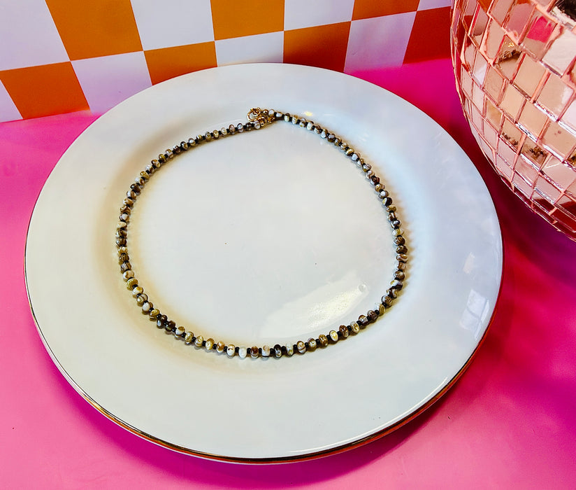 Drew 16.5-inch mother of pearl and chocolate seed bead necklace displayed on white plate