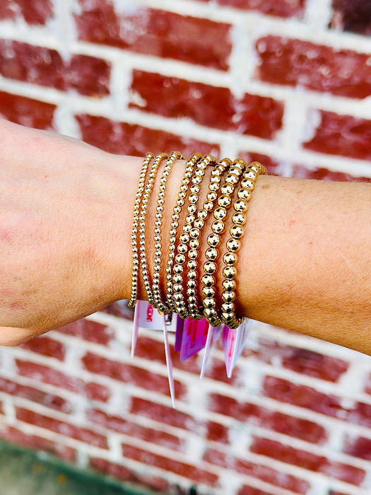 Gold filled bracelet stack featuring 2.5mm, 3mm, 4mm and 5mm bead sizes