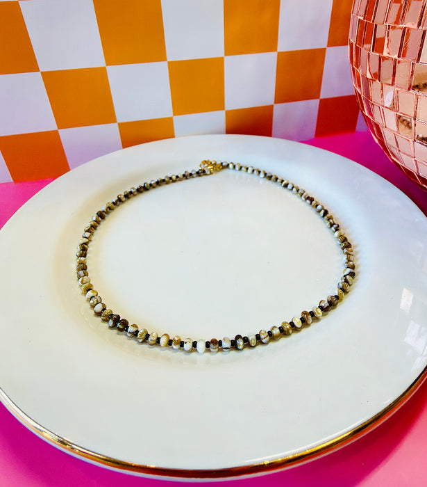 Drew Necklace with natural-colored mother of pearl and chocolate seed beads on white jewelry plate